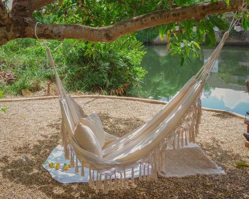 a hammock hanging from a tree in a garden at Gemstone Riverside, Chanthaburi in Chanthaburi