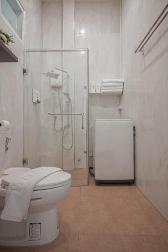 a bathroom with a toilet and a glass shower at Gemstone Riverside, Chanthaburi in Chanthaburi