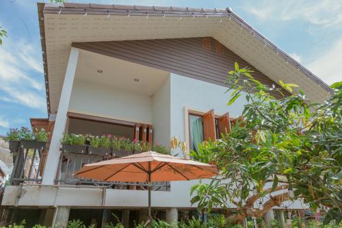 an orange umbrella sitting in front of a house at Gemstone Riverside, Chanthaburi in Chanthaburi