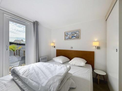 une chambre blanche avec un lit et une fenêtre dans l'établissement Mobil-home luxueux à Jullouville, 200m plage, piscine chauffée, pour 6 personnes - FR-1-361A-73, à Jullouville