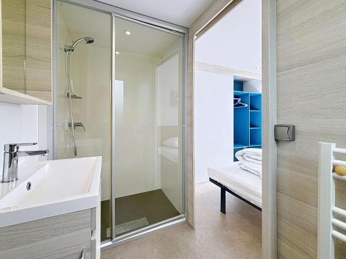 une salle de bain avec douche et lavabo dans l'établissement Mobil-home luxueux à Jullouville, 200m plage, piscine chauffée, pour 6 personnes - FR-1-361A-73, à Jullouville