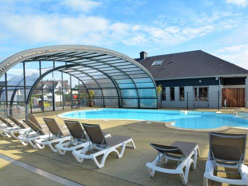 - un groupe de chaises longues à côté de la piscine dans l'établissement Tiny House bois avec terrasse, piscine, wifi, animaux admis, parking - 200m de la plage - FR-1-361A-88, à Jullouville