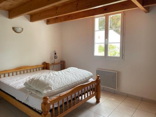 une chambre avec un lit en bois et une fenêtre dans l'établissement Maison mitoyenne à Barbâtre près de la plage - 4 personnes - FR-1-823-149, à Barbâtre