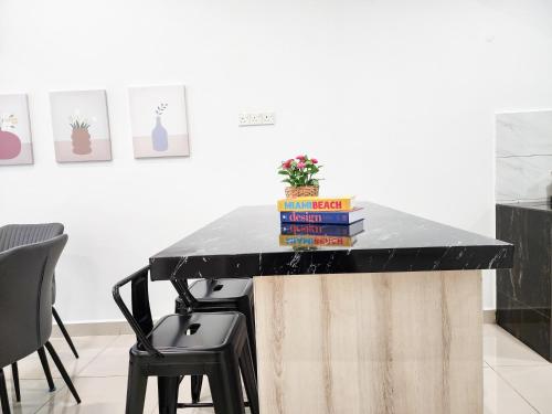 a table with books and a plant on top of it at Rawang Home near Aeon 15 Pax WIFI Game Smart TV in Rawang