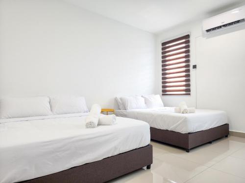 two beds in a room with white walls at Rawang Home near Aeon 15 Pax WIFI Game Smart TV in Rawang