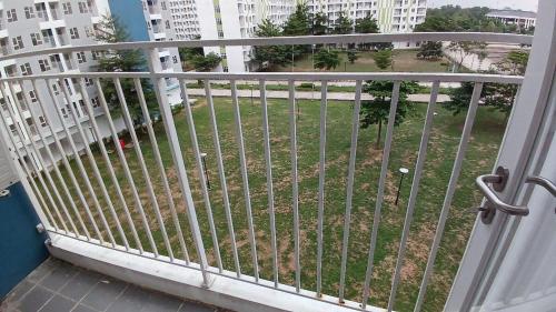 a balcony with a gate with a view of a park at Apartemen 2BR dekat Jakabaring Sport Center & Opi Mall in Baguskuning