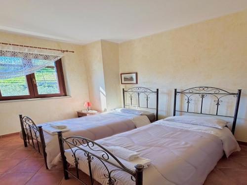 two twin beds in a bedroom with a window at Holiday Home in Sicily with Private Pool in Francavilla di Sicilia