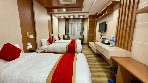 a hotel room with two beds and a sink at Hotel Ambrosia, Charikot, dolakha in Charikot