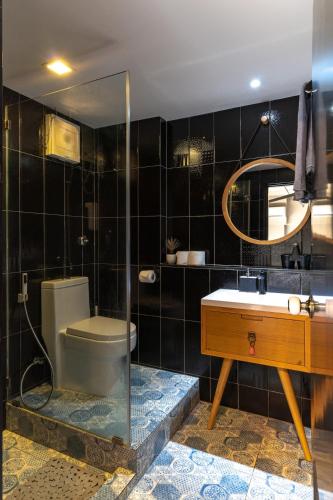 a bathroom with a toilet and a sink and a mirror at Thip Residence at Surawong in Bang Rak