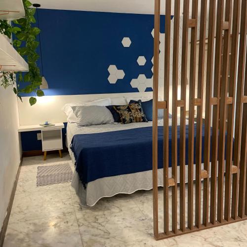 a bedroom with a bed with a blue wall with clouds at Rio Holiday Boutique Hotel in Niterói