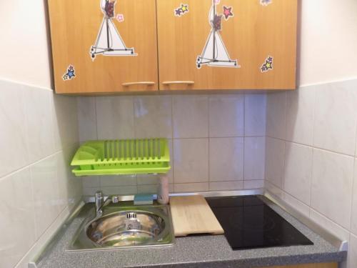 a kitchen with a sink and a green tray above it at Apartments Las Cabezas in Zadar