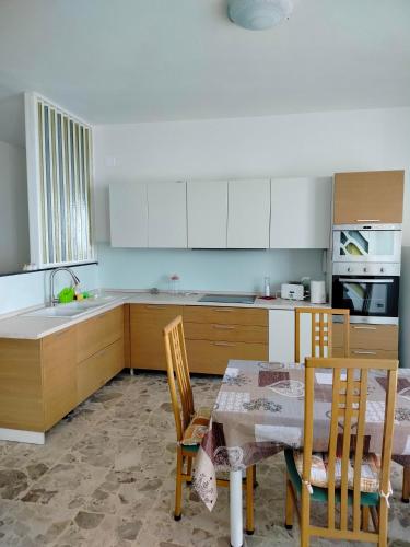 Una cocina con una mesa y sillas y un fregadero. en Radices in centro 1, en Campobasso
