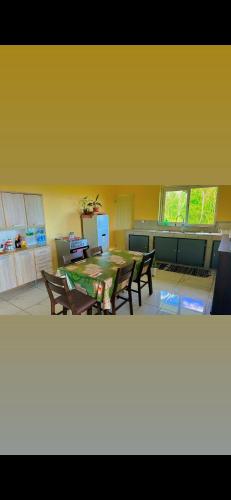 a kitchen with a table and chairs in a room at PUNAEI LODGE in Atuona