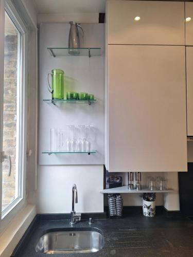 une cuisine avec un évier et une fenêtre dans l'établissement Plein Centre Charmant et Lumineux, à Paris