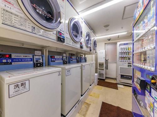 a laundry room with washers and dryers in a store at Nishitetsu Inn Kokura in Kitakyushu