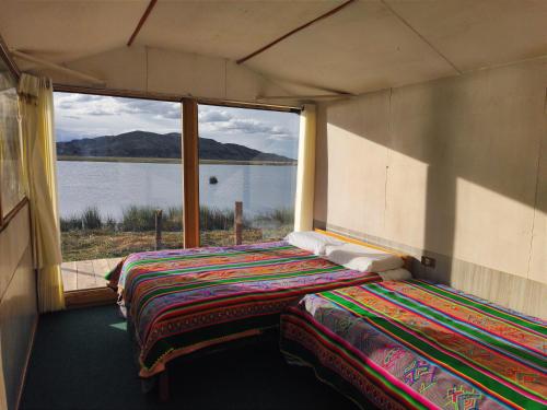 ein Bett in einem Zimmer mit einem großen Fenster in der Unterkunft Lago Titicaca in Puno
