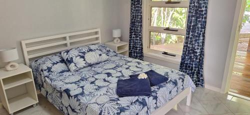 ein Schlafzimmer mit einem Bett mit einer blau-weißen Bettdecke in der Unterkunft Coconut Cottage Christmas Island in Flying Fish Cove
