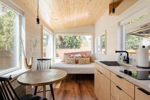 a kitchen with a table and a couch in a tiny house at Stay Portland - Mesa Tiny House Oasis on Alberta in Portland