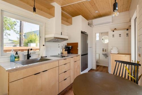 a kitchen with a sink and a table and a window at Stay Portland - Mesa Tiny House Oasis on Alberta in Portland