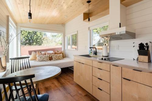 a kitchen and living room with a couch and a table at Stay Portland - Mesa Tiny House Oasis on Alberta in Portland
