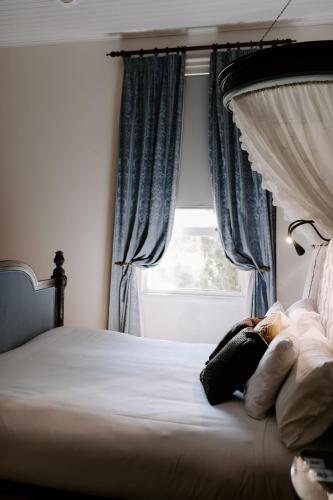 a woman laying on a bed in front of a window at The Abbey in Warwick