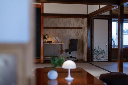 a living room with a desk and a chair at 期間限定連泊割-新幹線徒歩15分-空港車8分-田んぼに囲まれて暮らす自然に寄り添う静かな一棟貸切宿 in Hanamaki