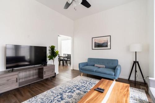 a living room with a blue couch and a tv at Stay Portland - Renovated 3BR Tilikum View in heart of SE Division in Portland