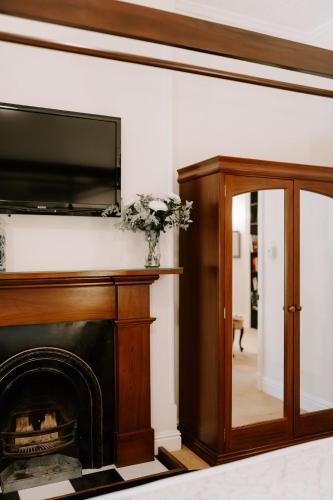 a living room with a fireplace and a television at The Abbey in Warwick