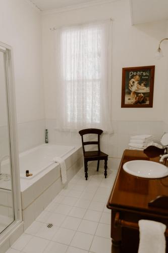 a white bathroom with a tub and a sink at The Abbey in Warwick