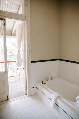 a white bathroom with a tub and a window at The Abbey in Warwick