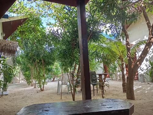 a wooden table in the middle of a park with trees at Seaview by Ukulhas in Filitheyo