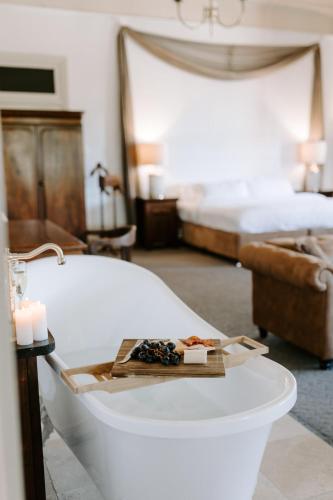 a bathroom with a bath tub with candles and a bed at The Abbey in Warwick