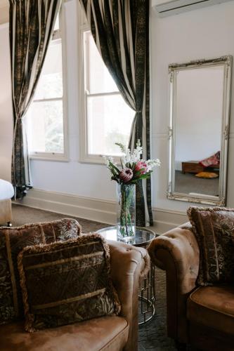 a living room with two couches and a mirror at The Abbey in Warwick