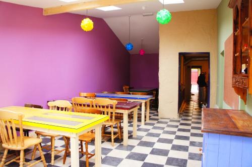 a restaurant with tables and chairs and purple walls at The Black Sheep Hostel in Killarney