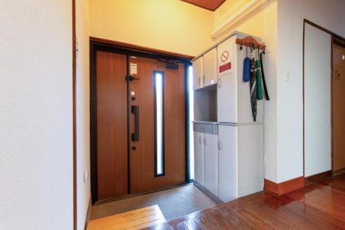 an empty hallway with a door and a refrigerator at 期間限定連泊割-新幹線徒歩15分-空港車8分-田んぼに囲まれて暮らす自然に寄り添う静かな一棟貸切宿 in Hanamaki