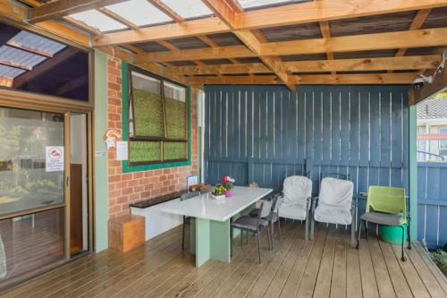 a patio with a table and chairs on a deck at Mini Homestay in Auckland