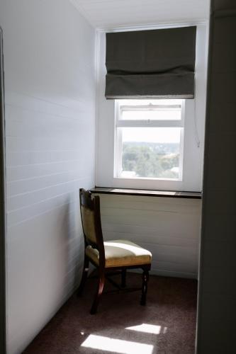 a chair in a room with a window at The Abbey in Warwick