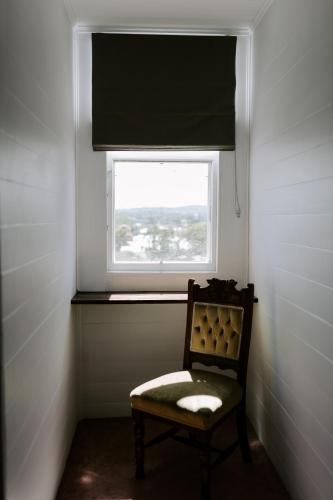 a chair in a room with a window at The Abbey in Warwick