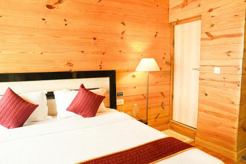 a bedroom with a bed with red pillows at Mountain BNB Hartola in Rāmgarh