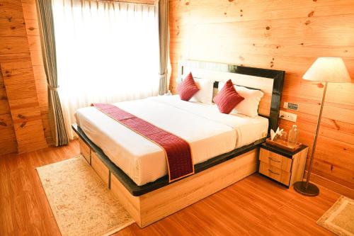 a bedroom with a bed in a wooden room at Mountain BNB Hartola in Rāmgarh