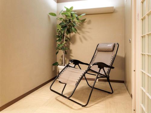 a black cat sitting in a chair in a room at Nishitetsu Inn Kokura in Kitakyushu