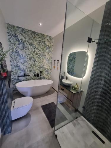 a bathroom with a tub and a toilet and a sink at Fifty Ridge in George