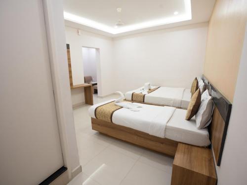a bedroom with two beds in a room at Grand Oliver in Chennai