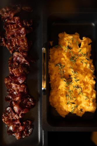 a tray of food with some meat and eggs at FRÄULEIN NANNERL - Boutique Apart mit Saunahaus in Gerlos