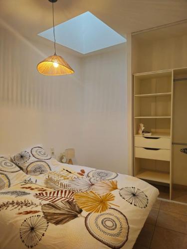 une chambre avec un lit avec une couette dessus dans l'établissement Appartement proche de la mer, à Pomérols