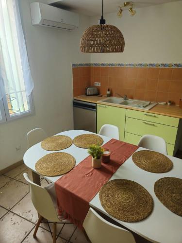Il dispose d'une cuisine avec une table et des chaises. dans l'établissement Appartement proche de la mer, à Pomérols