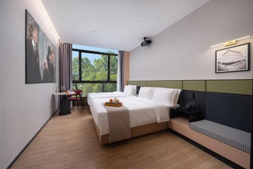 a bedroom with a large white bed and a window at Kainuo Garden Aesthetic Design Hotel Beijing Road - Shisanhang - Railway Station Metro Station - International Trade Center, Yuexiu District Guangzhou-- Reputation Preferred in Guangzhou