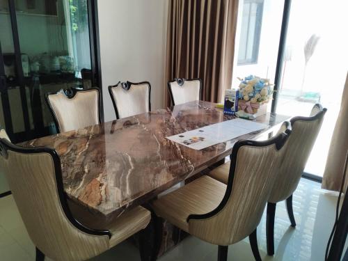 a dining room table with chairs and a marble counter top at Nanzarie House in Bang Kew Yai