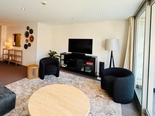 a living room with two chairs and a flat screen tv at Prime 3 bedrooms apartment with harbour views in Wellington Central in Wellington