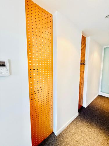 an orange door in a room with white walls at Prime 3 bedrooms apartment with harbour views in Wellington Central in Wellington
